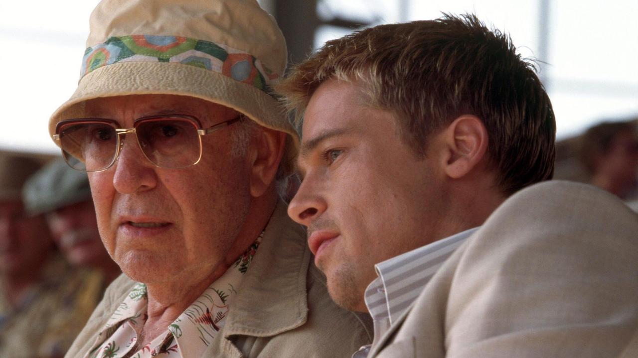 Carl Reiner links trägt einen Hut und Sonnenbrill und Brad Pitt rechts. Die Großaufnahme ist ein Filmstill aus "Ocean's Eleven", 2001. Pitt lehnt sich zu Reiner herüber. © Warner Brothers/courtesy Everett Collection