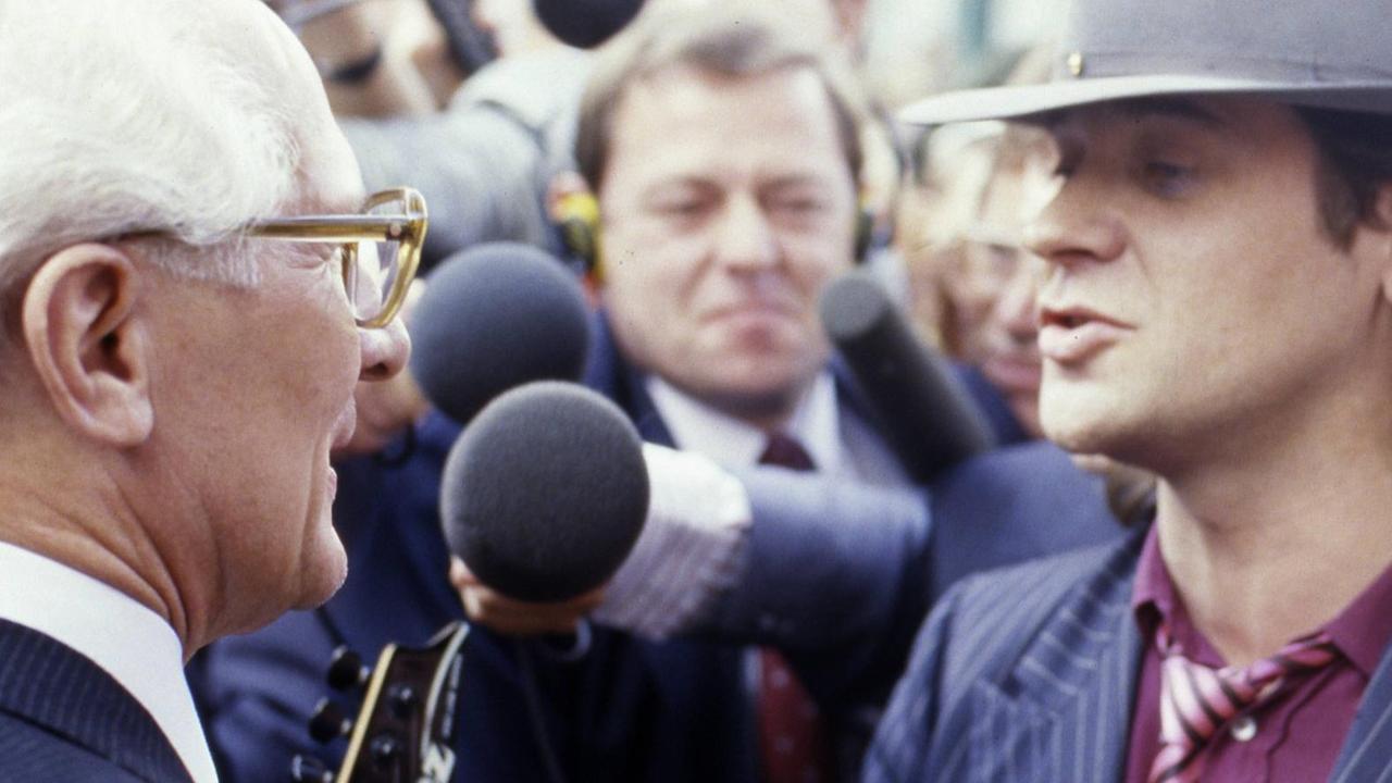 Lindenberg und Honecker stehen sich gegenüber von Menschen umringt.