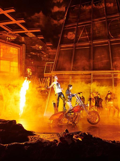 Ein Motorrad und viel Feuer auf der Bühne.