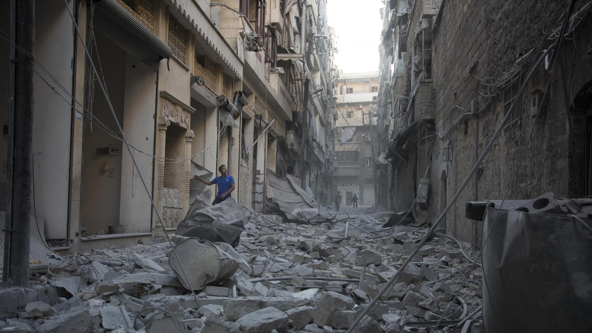 Ein Mann steht in Trümmern in Aleppo.