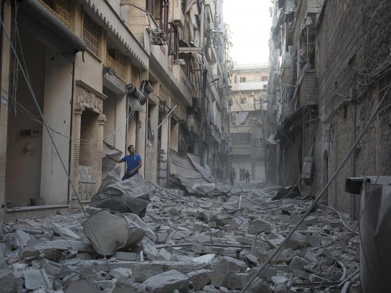 Ein Mann steht in Trümmern in Aleppo.