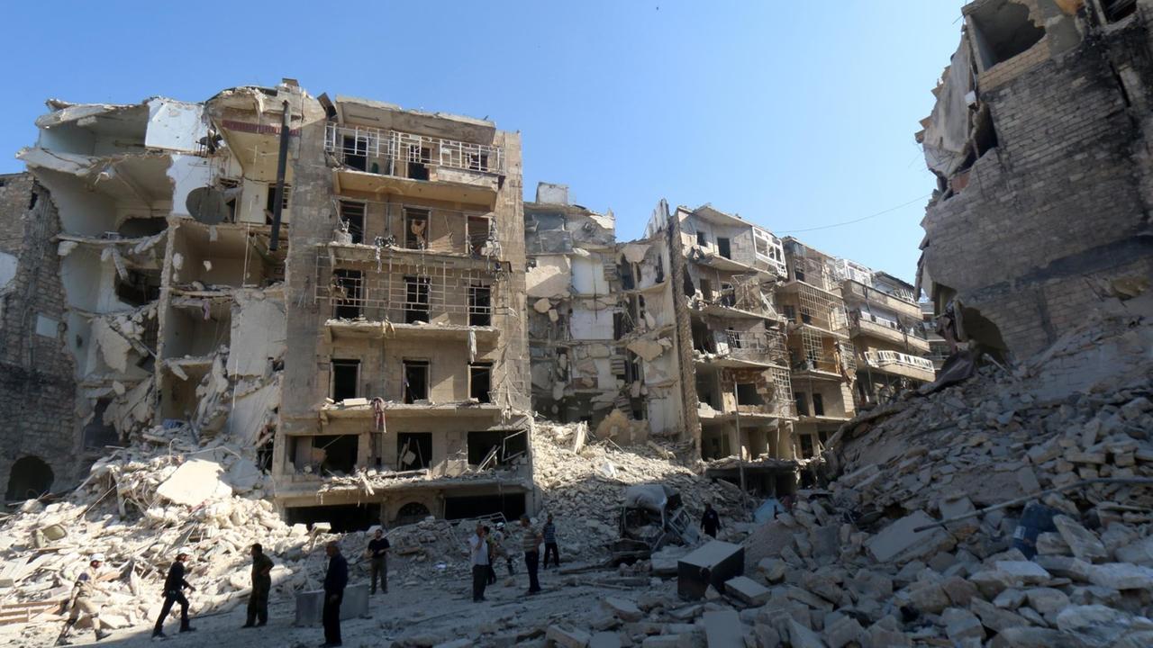 Menschen stehen vor zerstörten Häusern in der syrischen Stadt Aleppo 