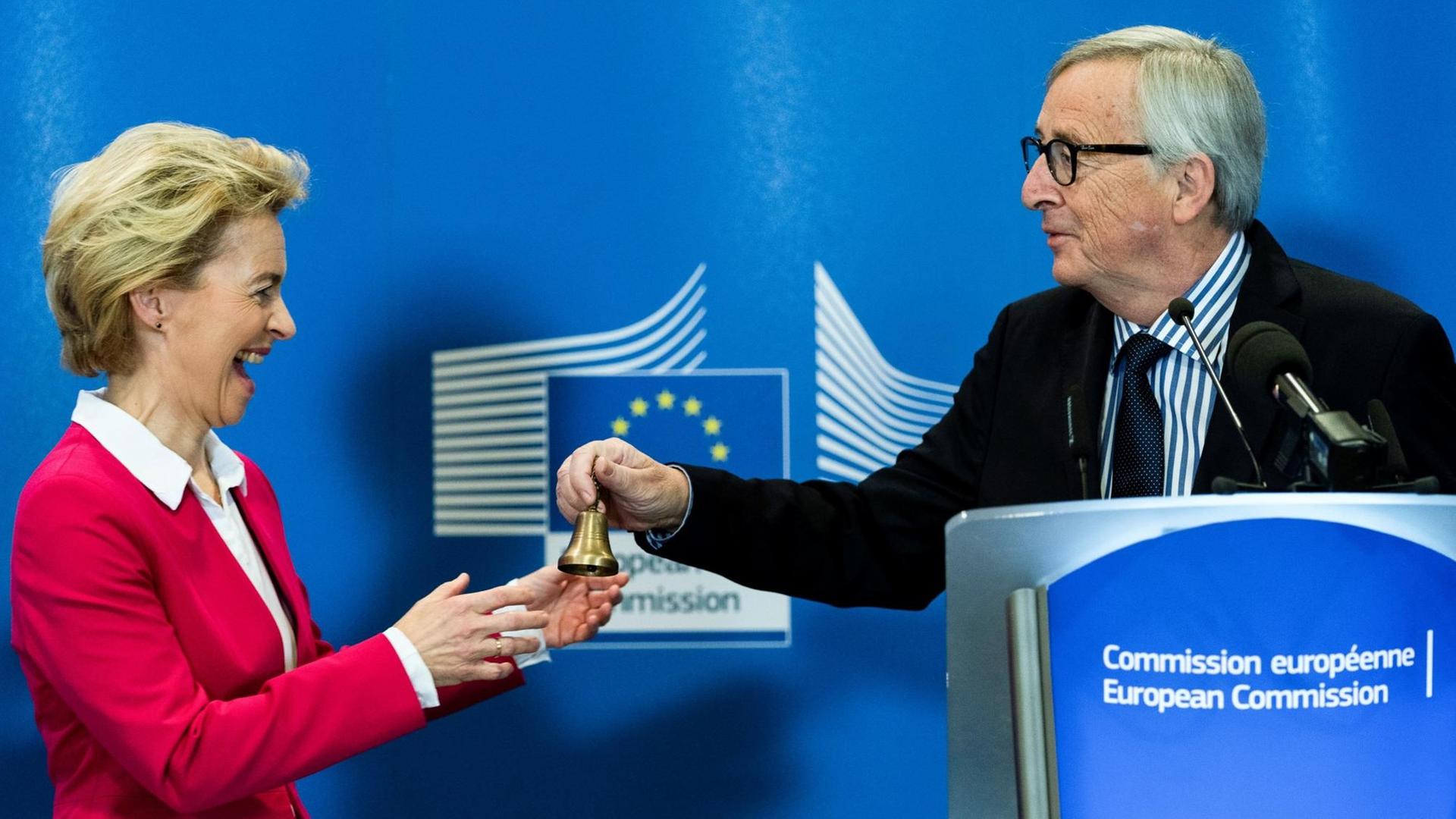 Der scheidende Präsident Jean-Claude Juncker (r.) überreicht der neuen Präsidentin der Europäischen Kommission Ursula von der Leyen eine Glocke.