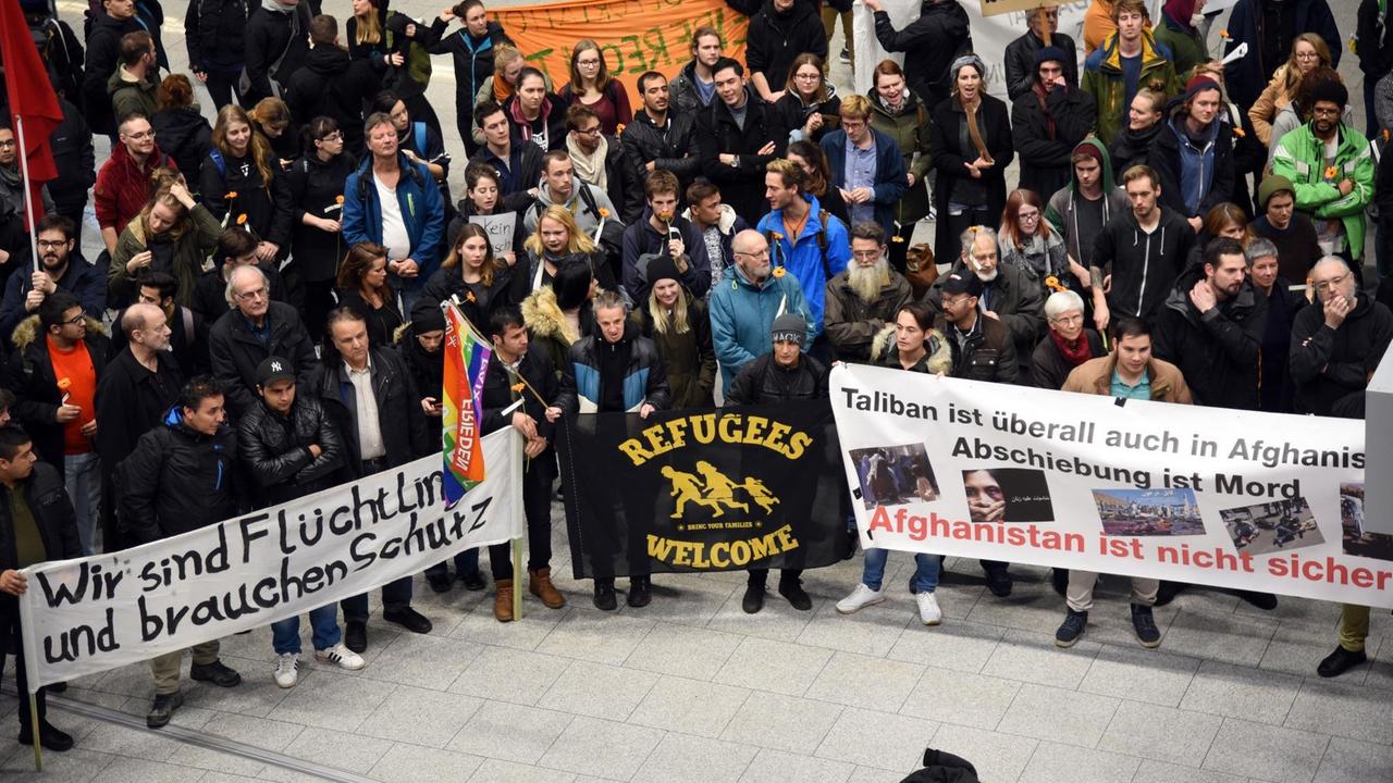 Banner mit Aufschriften wie "Wir sind Flüchtlinge und brauchen Schutz" halten Demonstranten am 23.01.2018 auf dem Flughafen in Düsseldorf (Nordrhein-Westfalen) bei einer Protestkundgebung der Flüchtlingsinitiativen gegen Sammelabschiebungen nach Afghanistan.