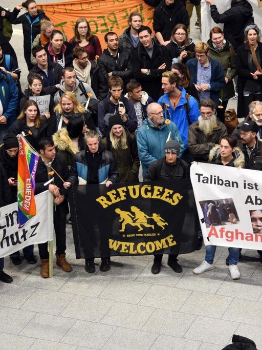 Banner mit Aufschriften wie "Wir sind Flüchtlinge und brauchen Schutz" halten Demonstranten am 23.01.2018 auf dem Flughafen in Düsseldorf (Nordrhein-Westfalen) bei einer Protestkundgebung der Flüchtlingsinitiativen gegen Sammelabschiebungen nach Afghanistan.