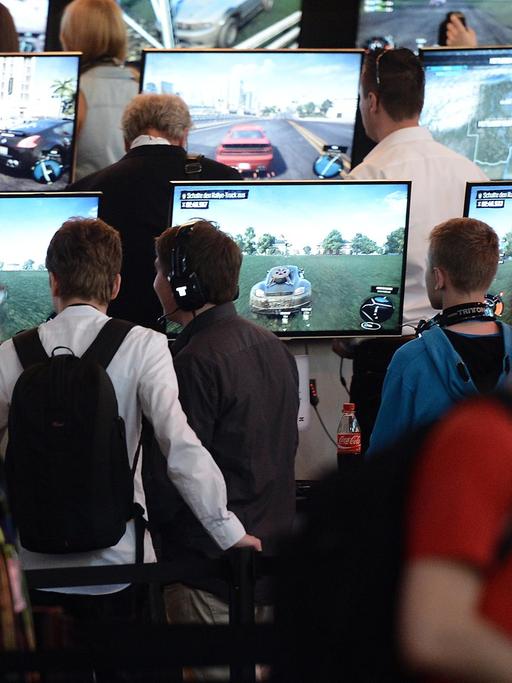 Besucher spielen am 13.08.2014 in Köln (Nordrhein-Westfalen) am Fachbesuchertag der Computerspielemesse "Gamescom" das Spiels "The Crew".