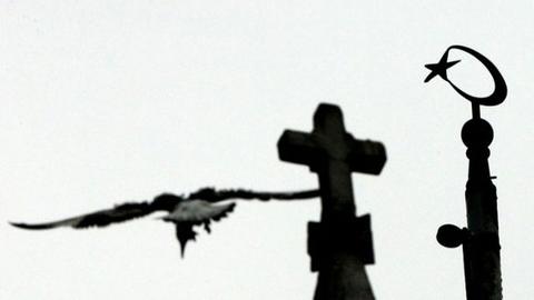 Ein Halbmond mit Stern neben dem Kreuz der armenischen Santa Maria Kirche in Istanbul.