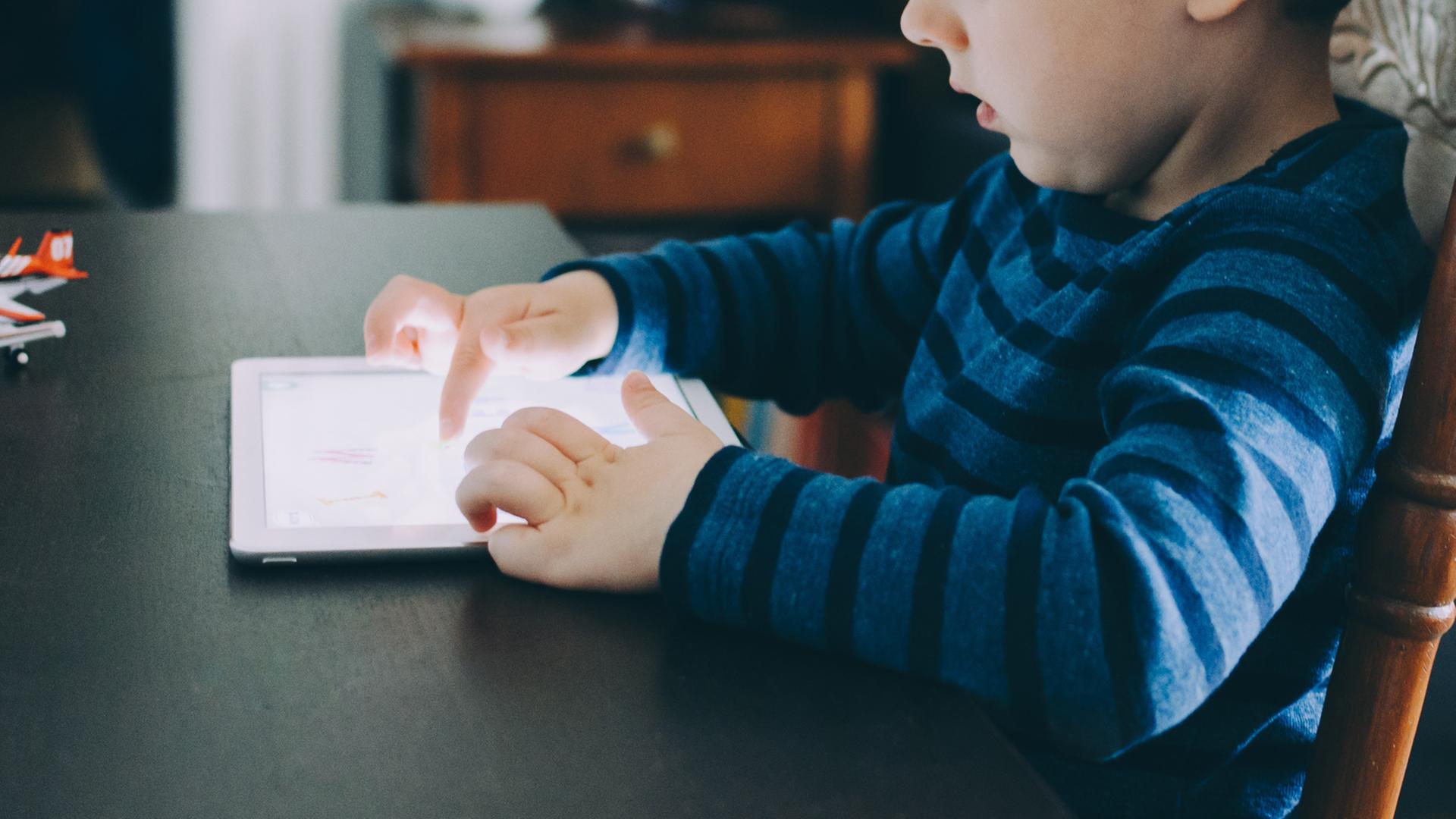 Ein Kind spielt mit einem Tablet. Ein Kind spielt mit einem Tablet.