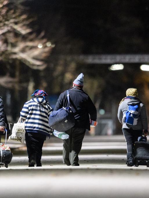 Obdachlose gehen am 14.12.2017 über das Gelände der Bayernkaserne in München (Bayern) in Richtung der Nachtunterkunft für Obdachlose.