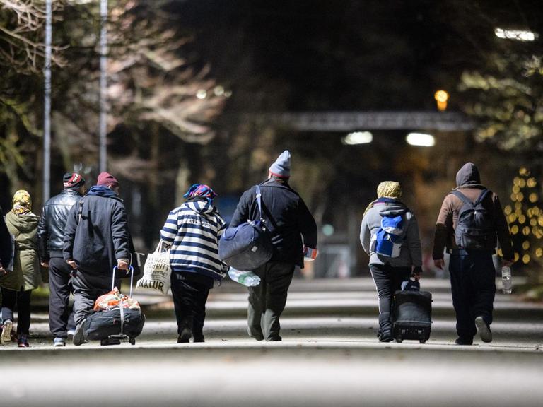 Obdachlose gehen am 14.12.2017 über das Gelände der Bayernkaserne in München (Bayern) in Richtung der Nachtunterkunft für Obdachlose.