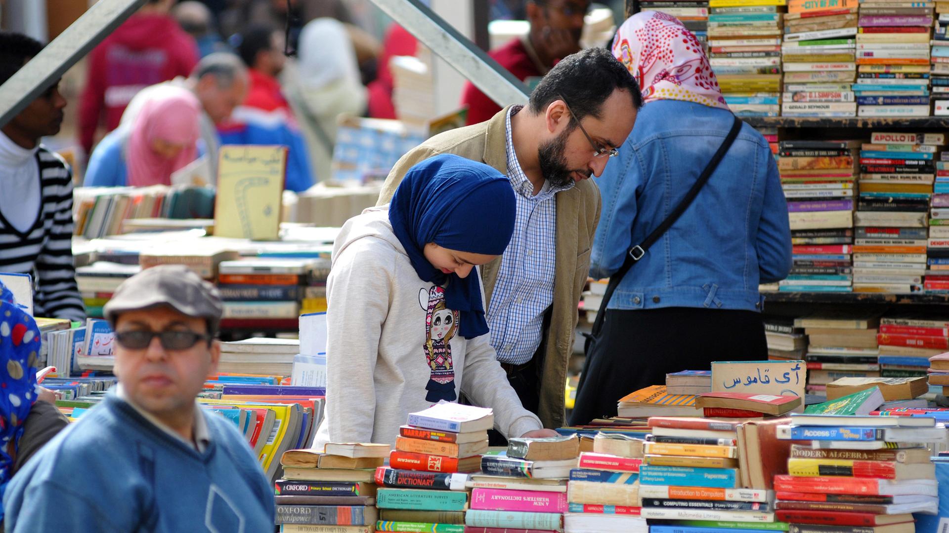 Ägyptische Besucher auf der Buchmesse in Kairo an einem Stand für gebrauchte Bücher
