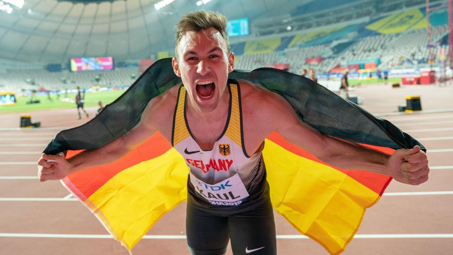 Niklas Kaul ist neuer Welt-Meister im Zehn-Kampf.. Er hat sich in eine Deutschland-Fahne um die Schultern gelegt und jubelt laut.