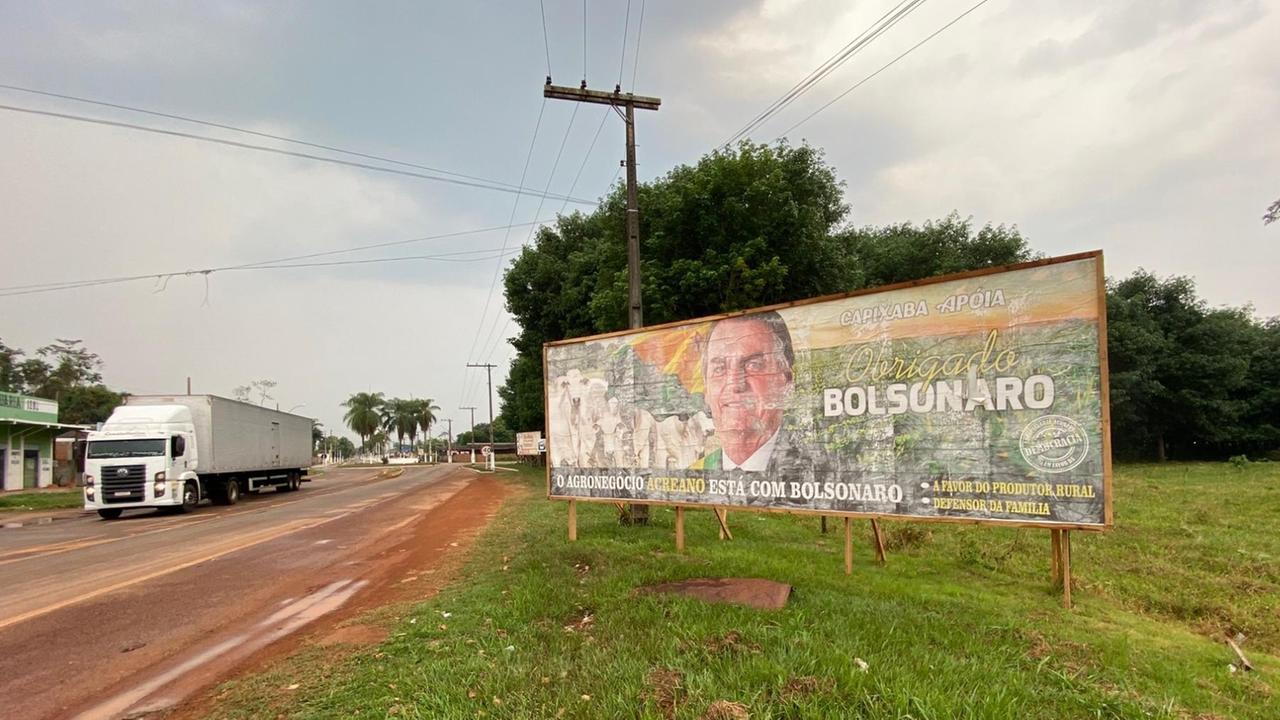 Ein Outdoor-Poster mit Präsident Bolsonaro steht neben einer Straße.