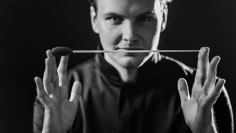 Portrait des Dirigenten der einen Taktstock in der Hand hält. (schwarzweiß Fotografie)