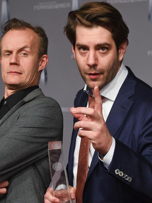 Die Comedians Max Uthoff (l) und Claus von Wagner halten am 13.01.2016 in Düsseldorf (Nordrhein-Westfalen) nach der Verleihung des Deutschen Fernsehpreises ihre Auszeichnung in der Kategorie "Beste Comedy / Kabarett" in den Händen. In mehr als 20 Kategorien wurde der Preis an Schauspieler und Produktionen vergeben.