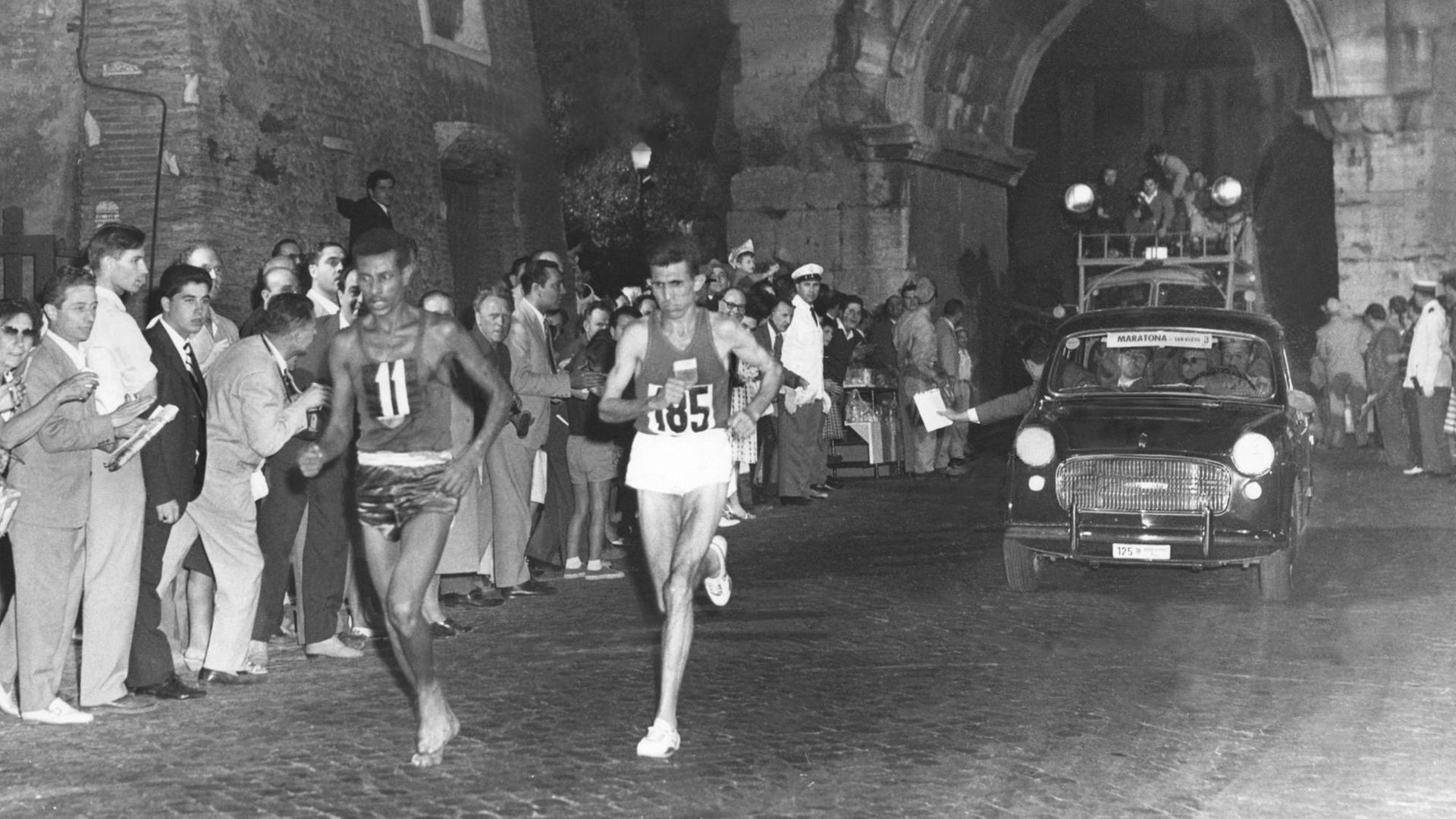 Gemeinsam mit dem späteren Zweitplatzierten Rhadi Ben Abdesselam (Marokko) passiert der 28-jährige Leibgardist von Kaiser Haile Selassie, Abebe Bikila, beim olympischen Marathonlauf in Rom die Porta San Sebastiano.