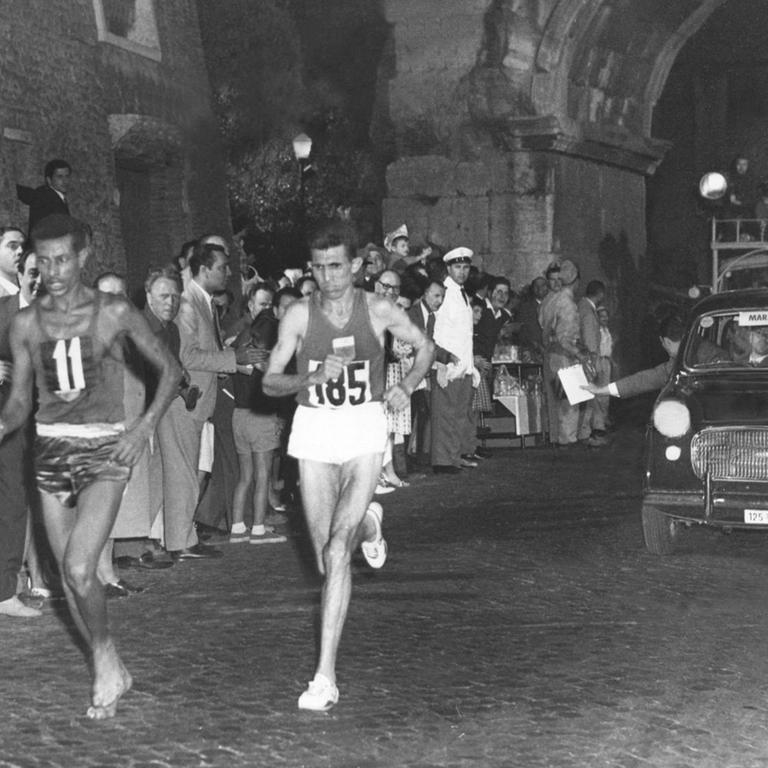 Gemeinsam mit dem späteren Zweitplatzierten Rhadi Ben Abdesselam (Marokko) passiert der 28-jährige Leibgardist von Kaiser Haile Selassie, Abebe Bikila, beim olympischen Marathonlauf in Rom die Porta San Sebastiano.