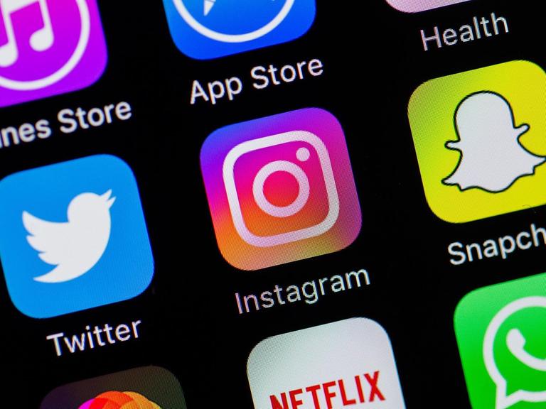 Auf einem Smartphone-Display sind die Logos von Twitter, Instagram und Snapchat zu sehen.