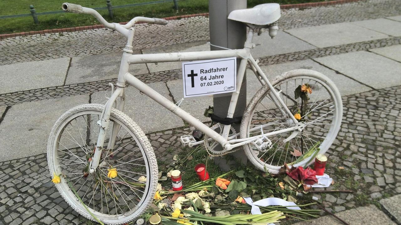 Der ADFC stellt zur Erinnerung an getötete Radfahrer in Berlin "Geisterräder" auf. Sie sind weiß gefärbt und mit Blumen umringt.