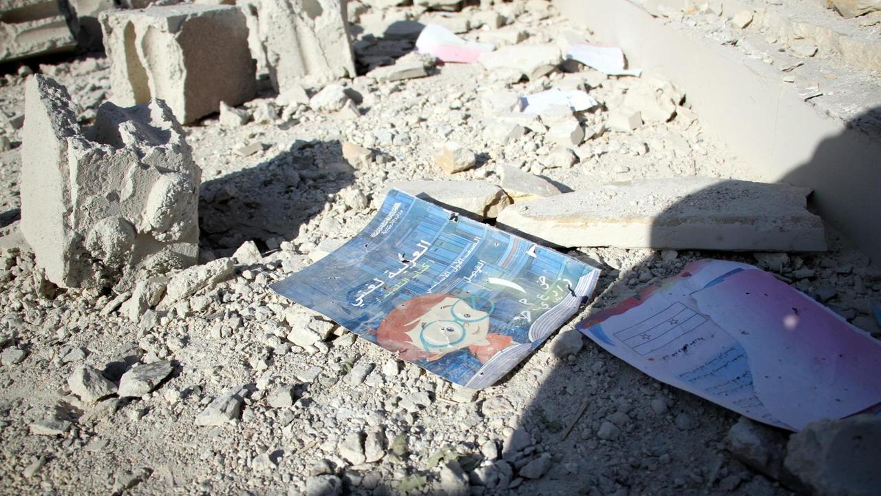 Ein Buch in arabischer Sprache liegt auf dem Boden einer Schule in Idlib/ Syrien, die bombardiert wurde