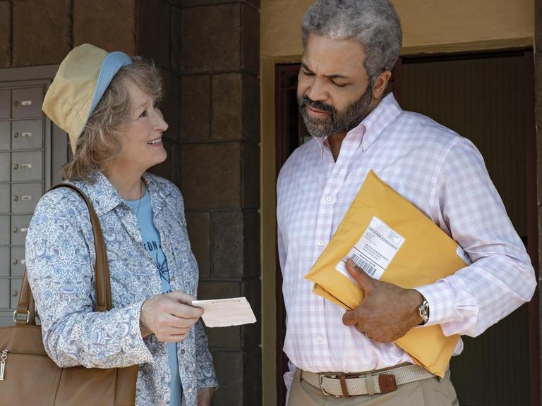 Die Schauspieler Meryl Streep und Jeffrey Wright im Film "The Laundromat: Die Geldwäscherei" - sie steht am Briefkasten und er trägt Briefumschläge in der Hand
