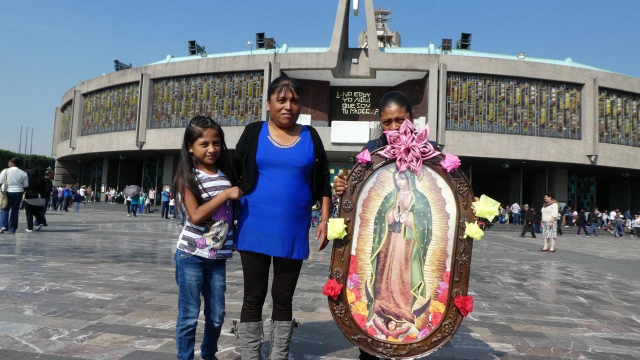 Besucherinnen der Basilika mit einem Heiligenbild für die Jungfrau von Guadalupe.