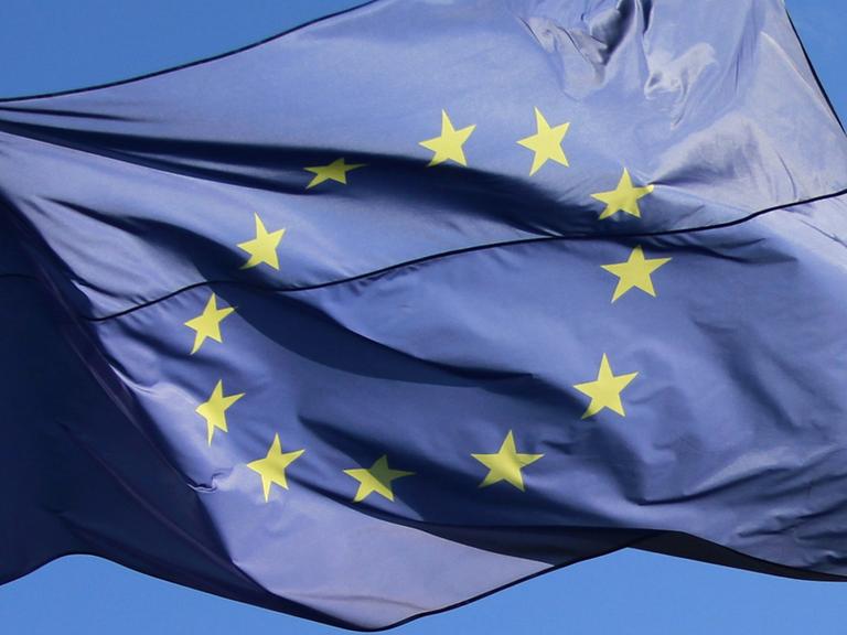 Eine europäische Fahne weht unter blauem Himmel.