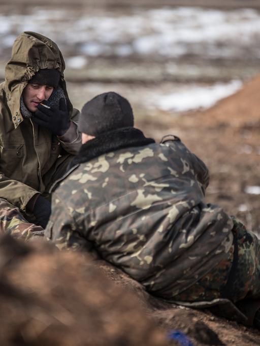 Ukrainische Soldaten in der Region Donezk ruhen sich auf einem Feld aus.