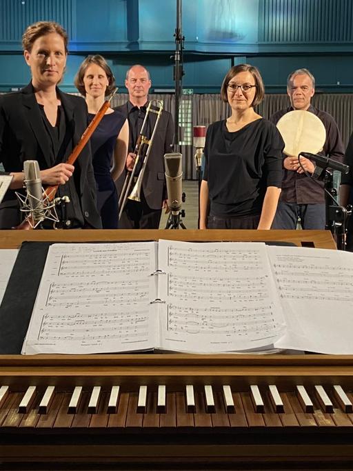 Über die Tasten einer Truhenorgel hinweg kann man die Mitglieder des Ensembles mit ihren Instrumenten sehen.