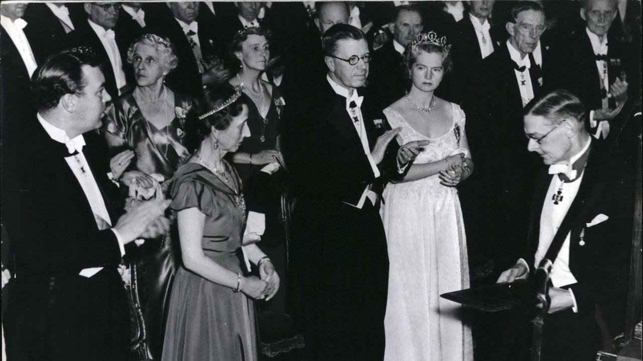 T. S. Eliot (rechts), nachdem er seinen Nobelpreis von Kronprinz Gustav erhalten hat, der applaudiert. (von links nach rechts) Prinz Bertil, Prinzessin Louise, der Kronprinz und Prinzessin Sibylla.