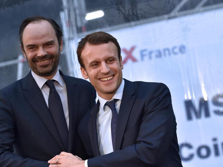 Edouard Philippe und Emmanuel Macron schütteln sich die Hand.