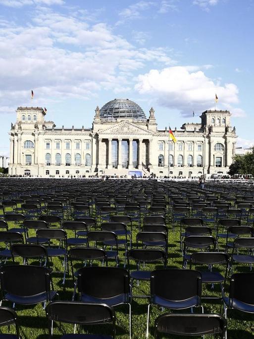 Tausende Stühle stehen auf dem Rasen vor dem Reichstagsgebäude in Berlin, um an das Schicksal der Geflüchteten auf Lesbos aufmerksam zu machen.