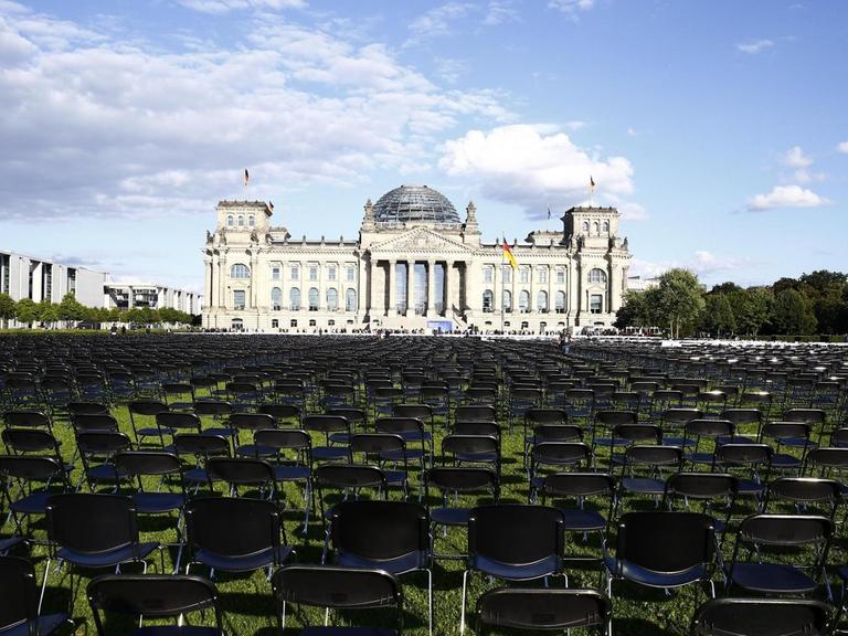 Tausende Stühle stehen auf dem Rasen vor dem Reichstagsgebäude in Berlin, um an das Schicksal der Geflüchteten auf Lesbos aufmerksam zu machen.