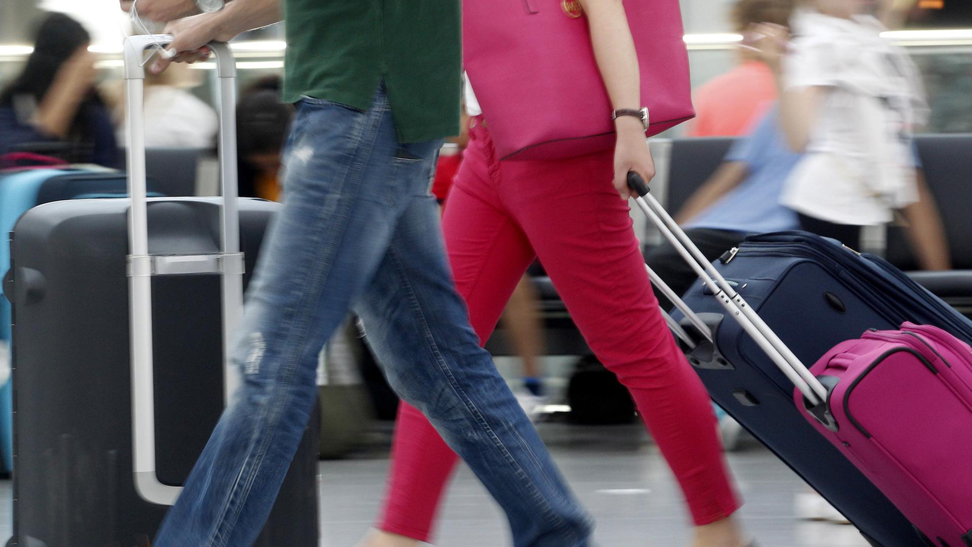 Reisende bringen am 19.07.2013 auf dem Flughafen in Düsseldorf ihr Gepäck zu den Flugschaltern.