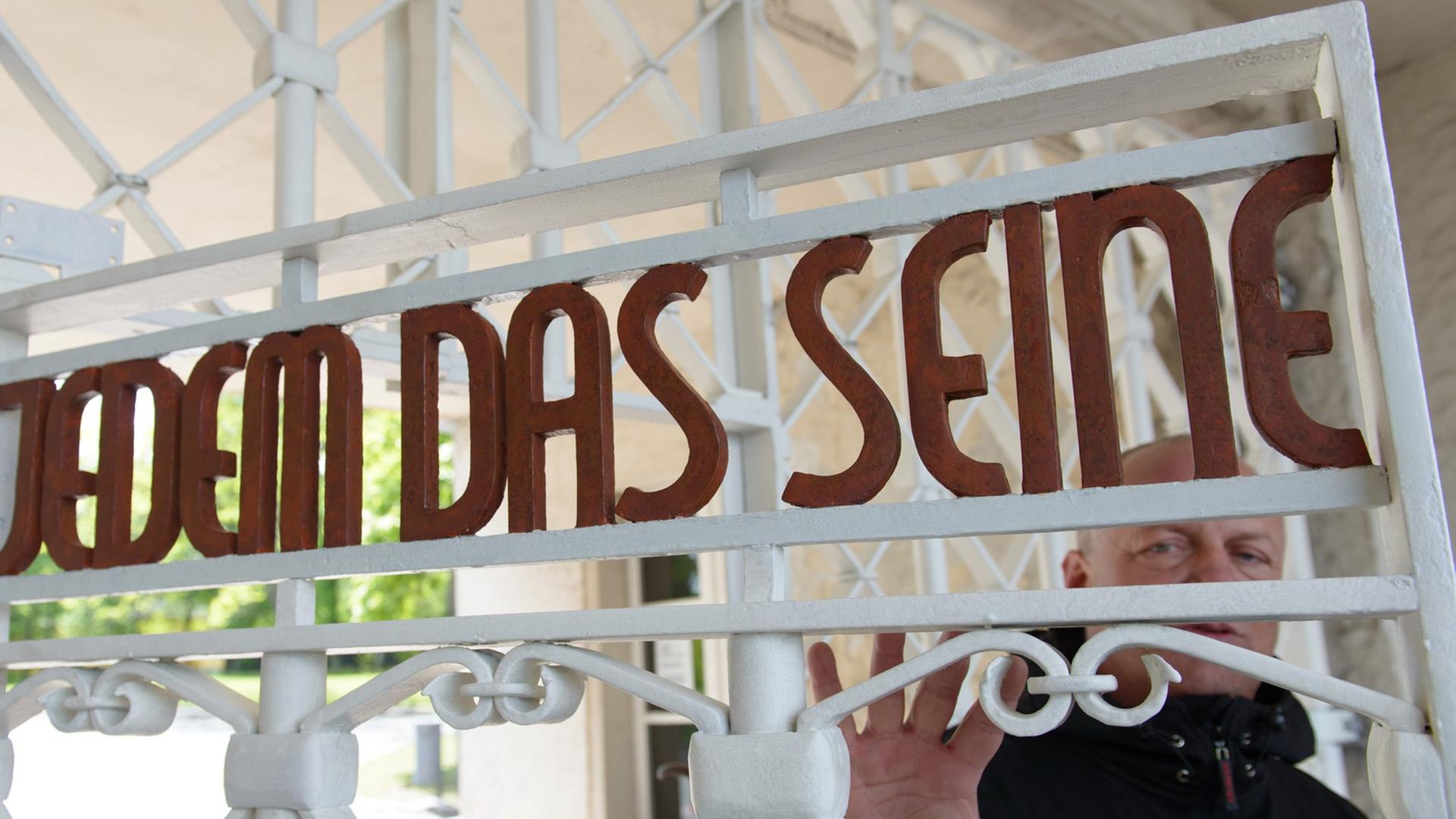 Restaurator Bernhard Mai steht in der Gedenkstätte Buchenwald am restaurierten und nach Befunden in den originalen Farben gestrichene Lagertor des ehemaligen Konzentrationslagers mit der Inschrift "Jedem das Seine".