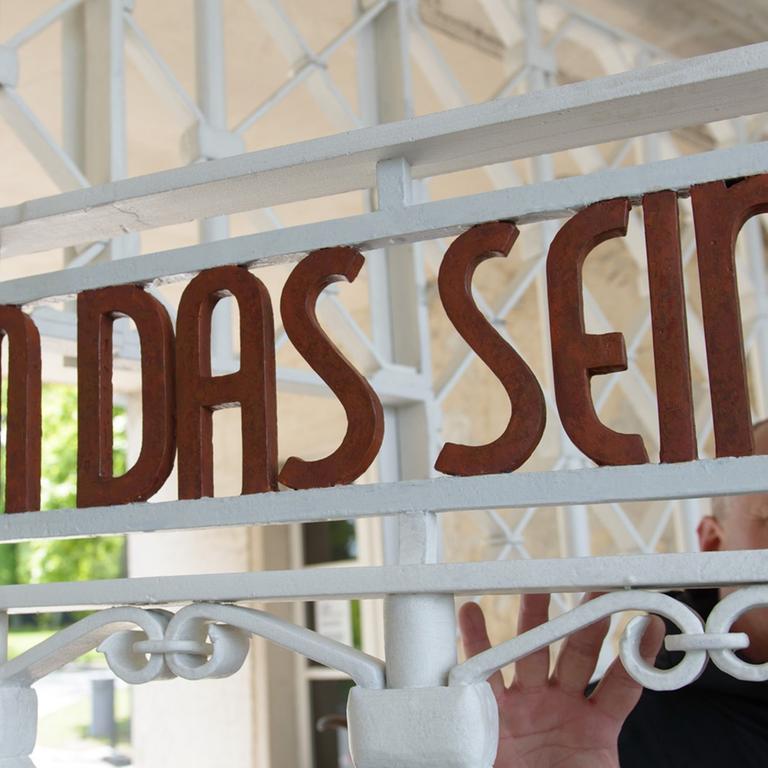 Restaurator Bernhard Mai steht in der Gedenkstätte Buchenwald am restaurierten und nach Befunden in den originalen Farben gestrichene Lagertor des ehemaligen Konzentrationslagers mit der Inschrift "Jedem das Seine". 
