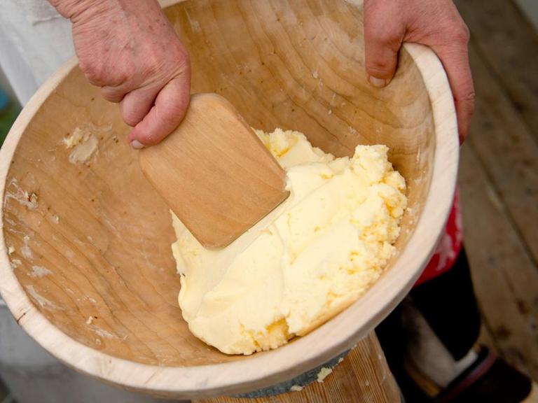 Butterproduktion im Butterfass: Eine Frau knetet auf der brandenburgischen Landwirtschaftsausstellung Butter aus.