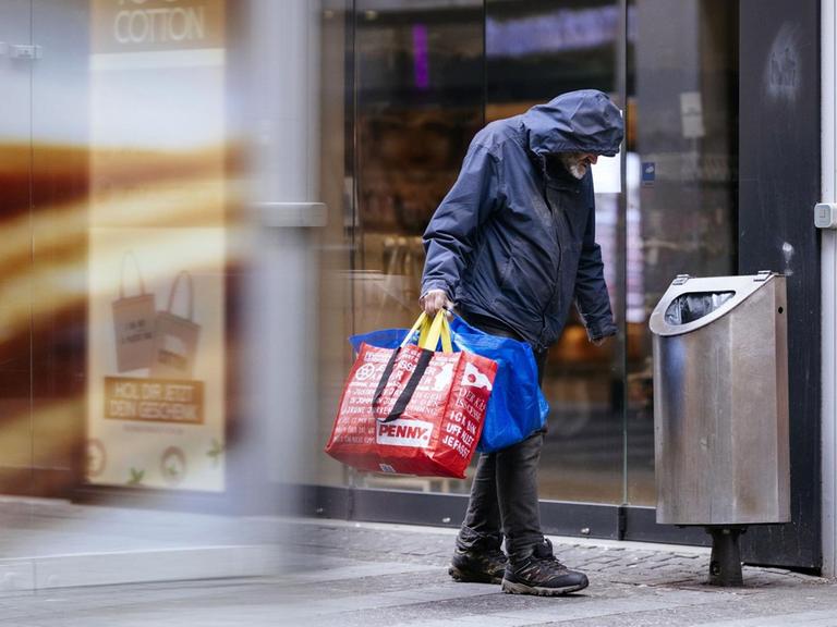 Ein Obdachloser sammelt Flaschen in der Kölner Innenstadt, Ende März 2020 | Verwendung weltweit