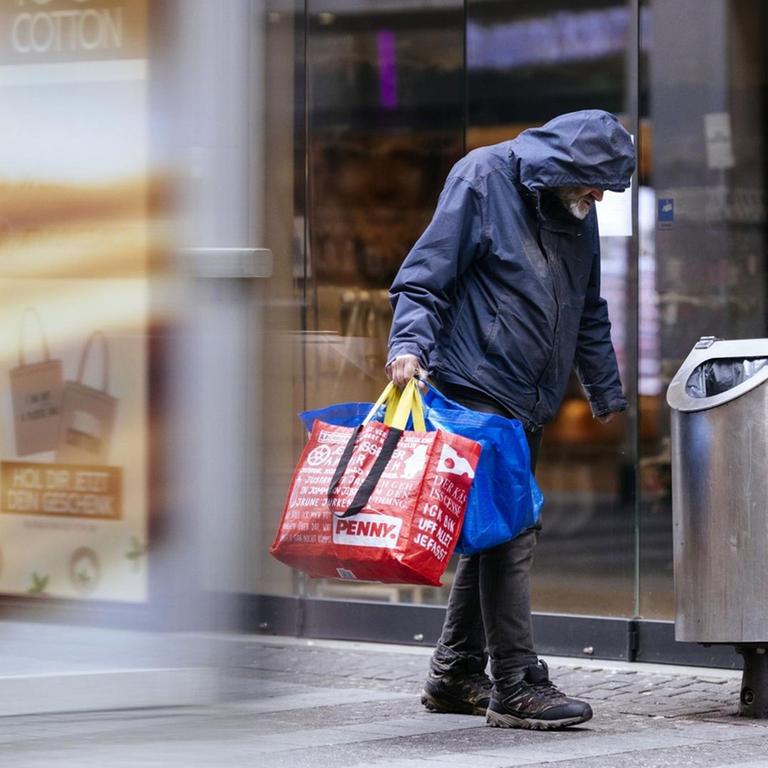 Ein Obdachloser sammelt Flaschen in der Kölner Innenstadt, Ende März 2020 | Verwendung weltweit