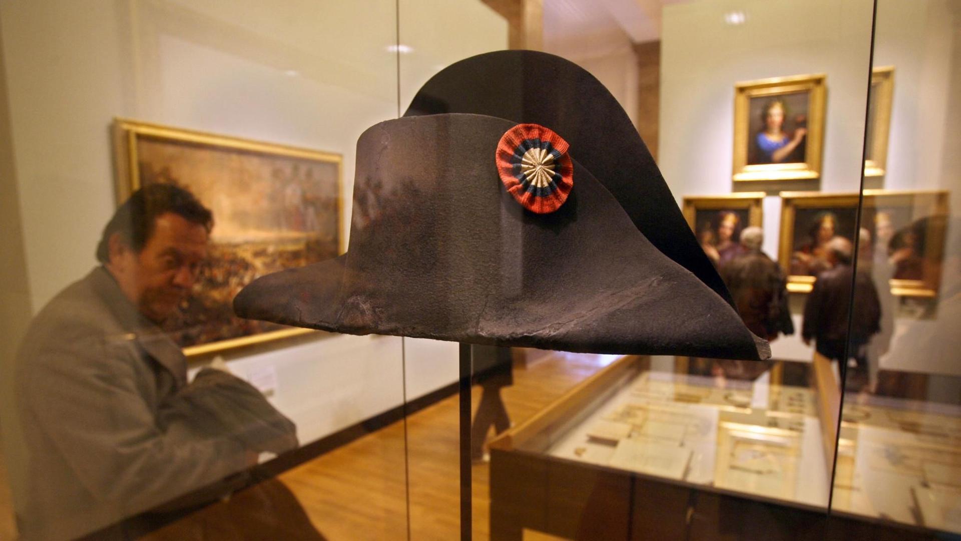 Ein Besucher schaut sich den Hut von Kaiser Napoleon an. Dieser hatte ihn in der berühmten Schlacht von Waterloo verloren. Der Hut ist Teil einer Dauerausstellung im Deutschen Historischen Museum in Berlin. Foto: AFP PHOTO JOHN MACDOUGALL