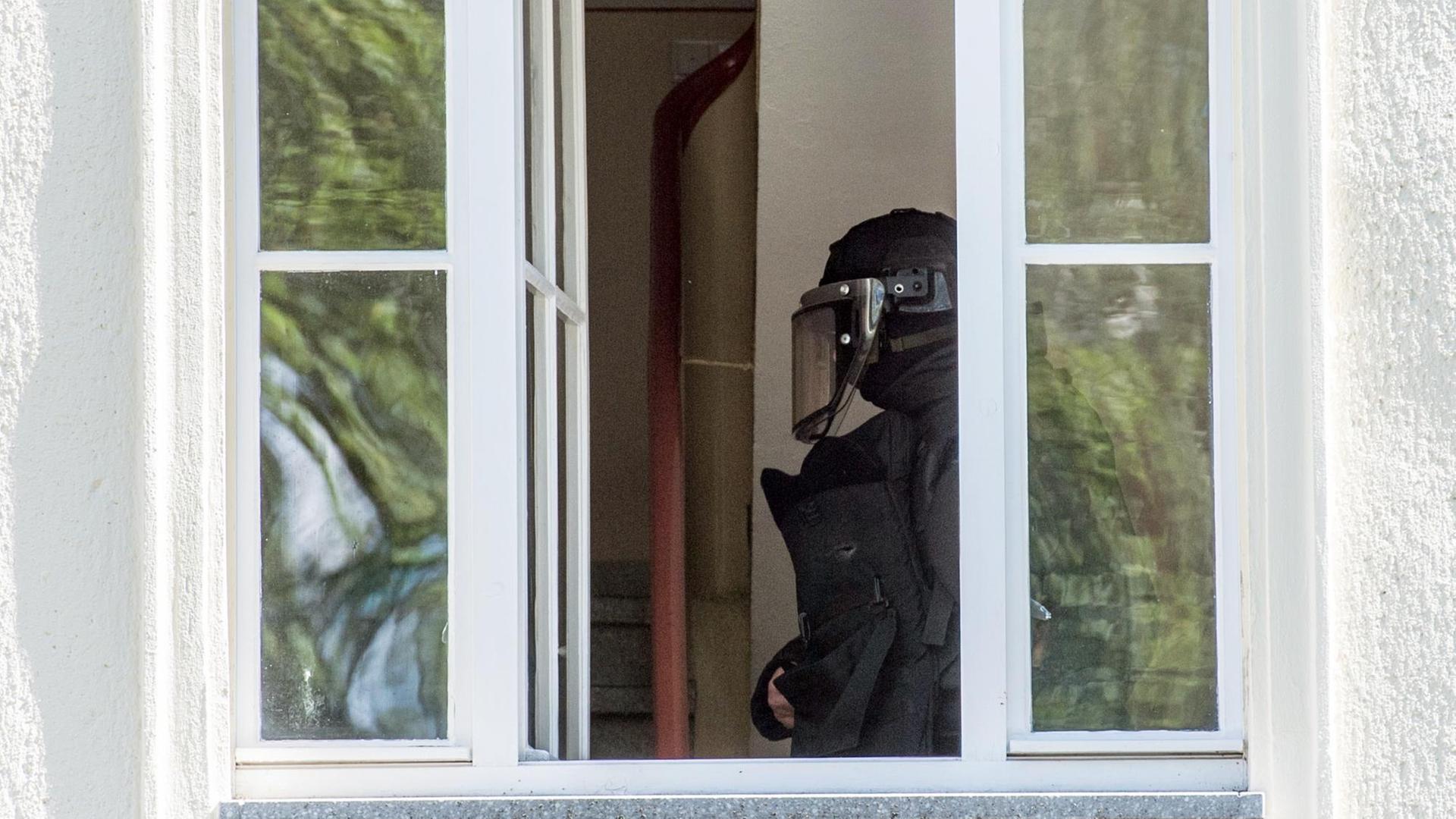 Ein Beamter des Spezialeinsatzkommando ist an einem Fenster in einem Haus zu sehen. Ein Beamter des Spezialeinsatzkommando ist an einem Fenster in einem Haus zu sehen.