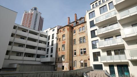 30.01.2019, Sachsen, Leipzig: Ein leerstehender, unsanierter Altbau steht zwischen noch unbewohnten Neubauten im Zentrum der Stadt, im Hintergrund ist das Wintergartenhochhaus zu sehen.