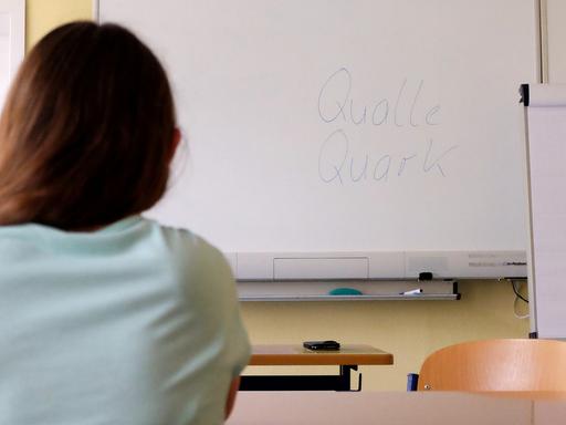 Eine Teilnehmerin des Alphabetisierungskurses sitzt am 30.08.2016 im Klassenzimmer der VHS Erfurt (Thüringen).