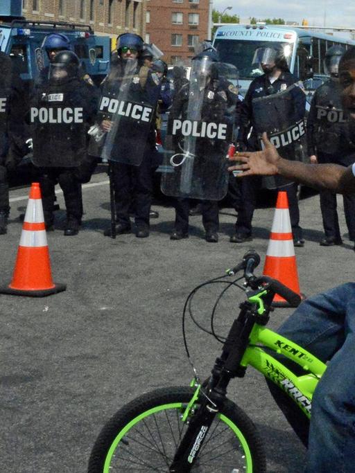 EIn Jugendlicher albert vor einer Polizeikette