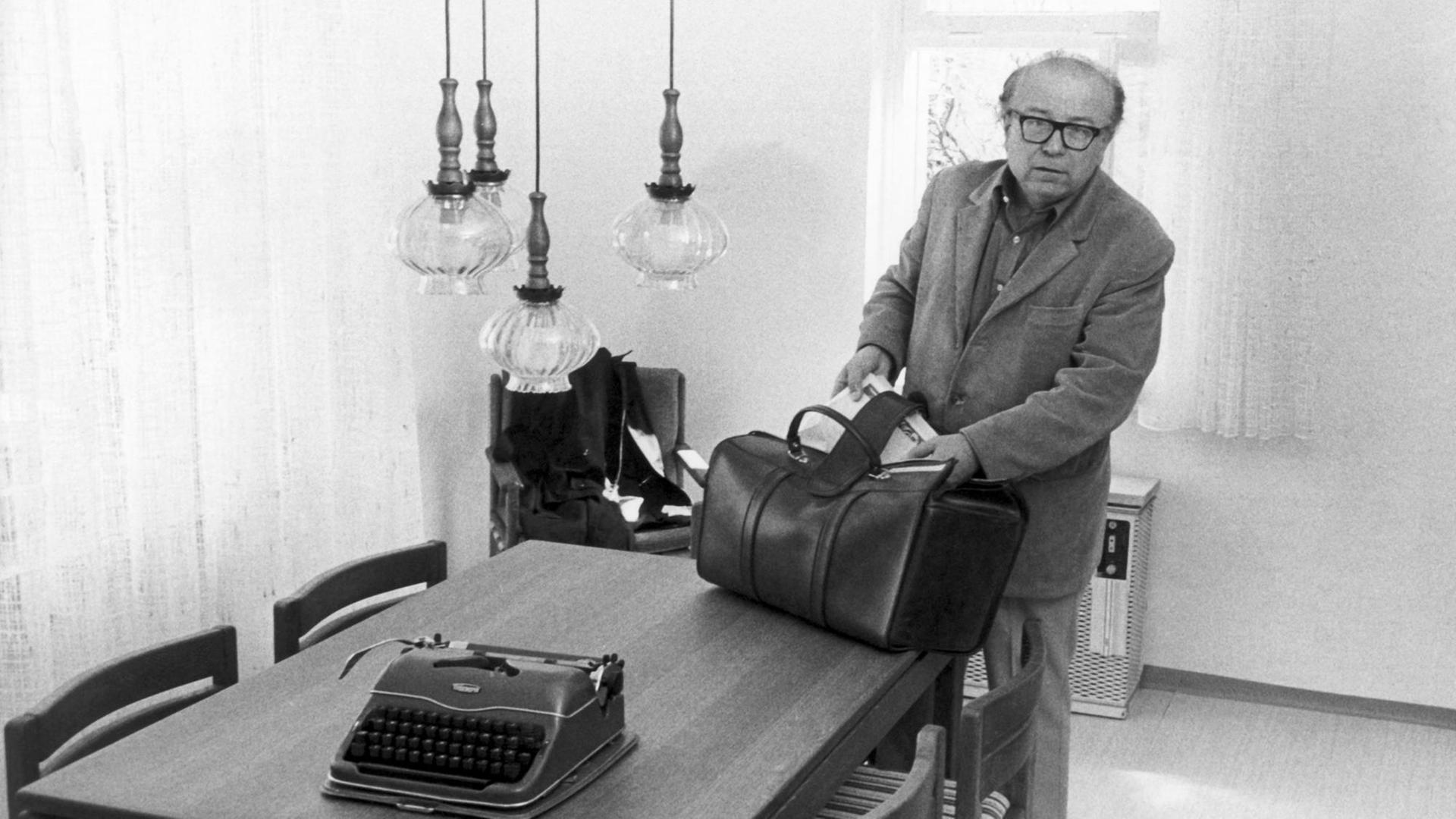 Der Münchner Schriftsteller Wolfgang Koeppen packt am 28.04.1975 in seinem kostenlosen Domizil in Bergen-Enkheim eine Tasche aus.