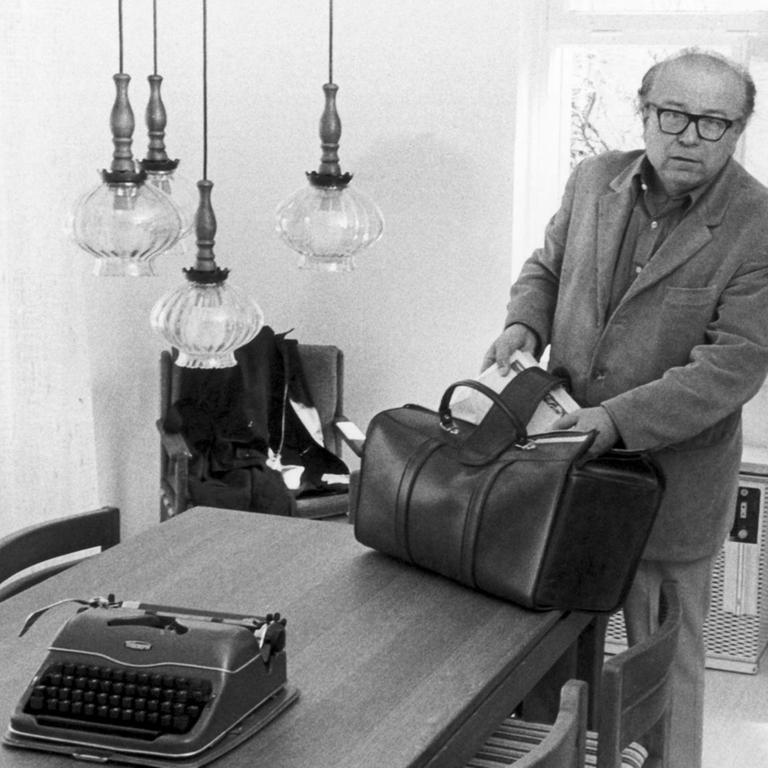 Der Münchner Schriftsteller Wolfgang Koeppen packt am 28.04.1975 in seinem kostenlosen Domizil in Bergen-Enkheim eine Tasche aus. 