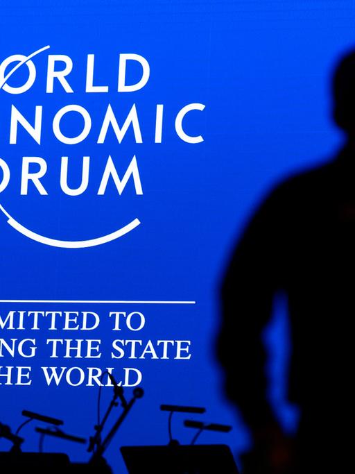 Das Logo des Weltwirtschaftsforum mit der Unterzeile "Committed to Improving the State of the World", davor der Schattenriss eines Mannes.