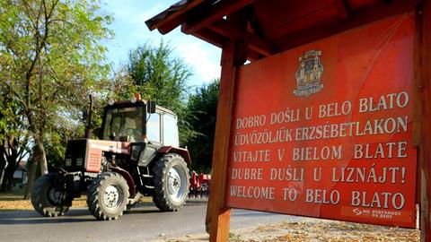 Ein Ortsschild in verschiedenen Sprachen steht am Ortseingang von Belo Bato