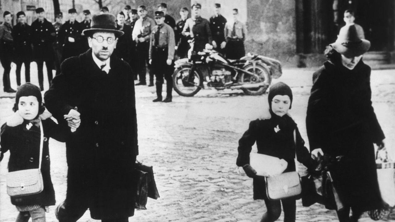 Eine jüdische Familie flüchtet unter dem Gelächter von Wehrmachtssoldaten