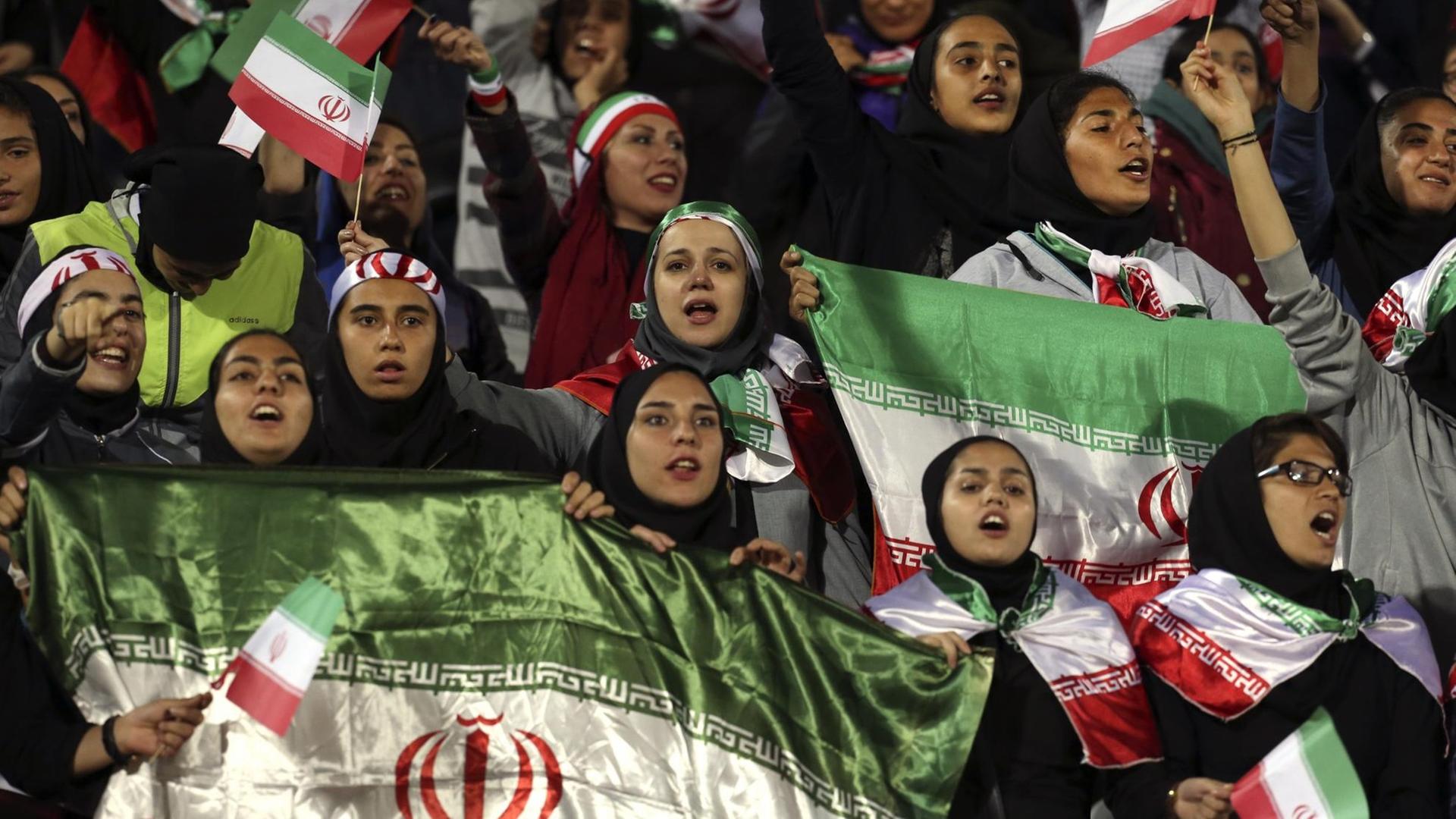 Iranische Frauen schwenken beim Spiel gegen Bolivien im Teheraner Asadi Stadion Flaggen ihres Landes.